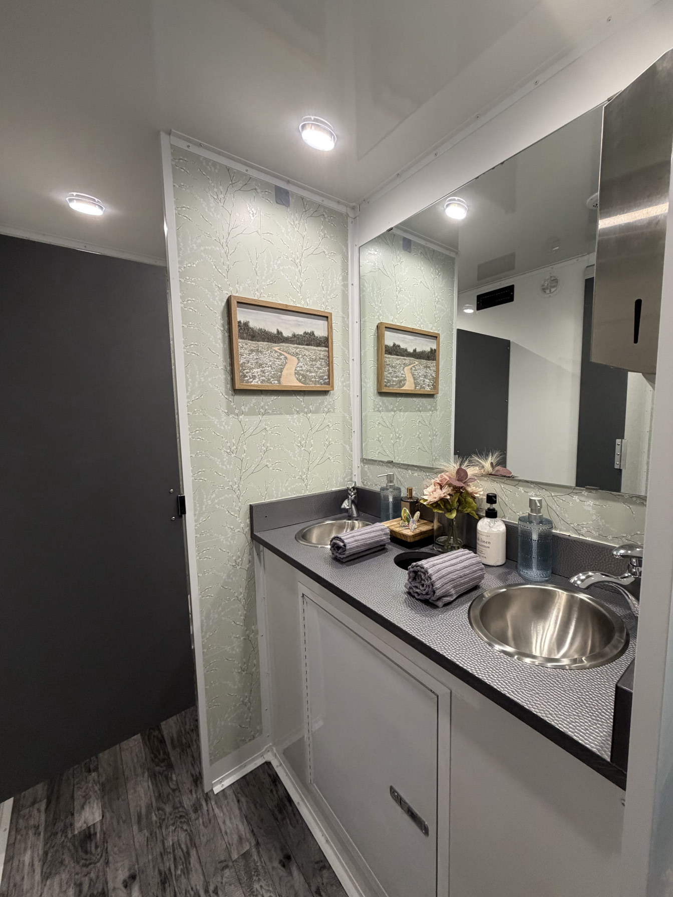 Restroom trailer hallway vanity with mirror and running-water sink